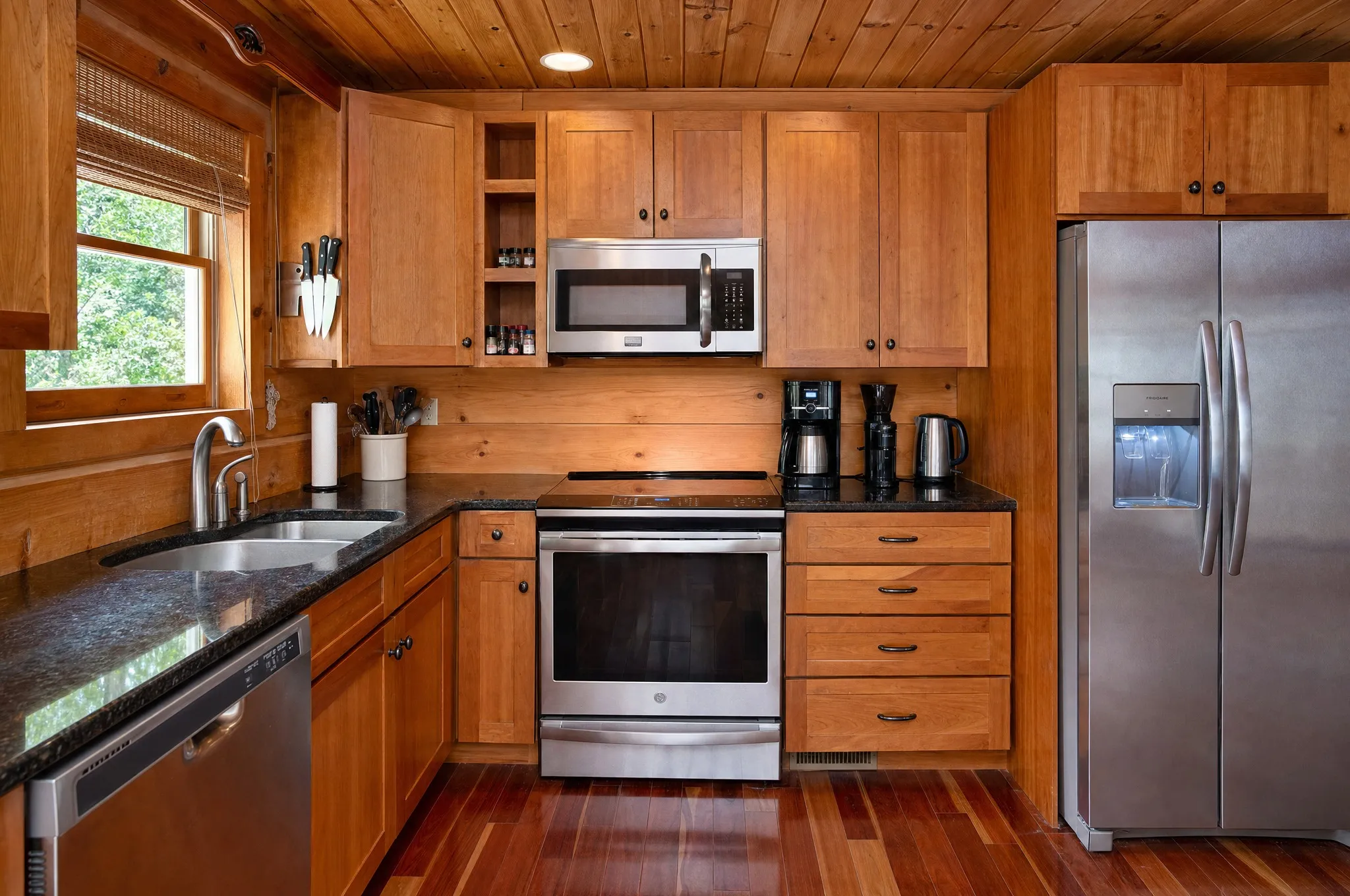 Remodeled kitchen with stainless steel range, microwave, and refrigerator