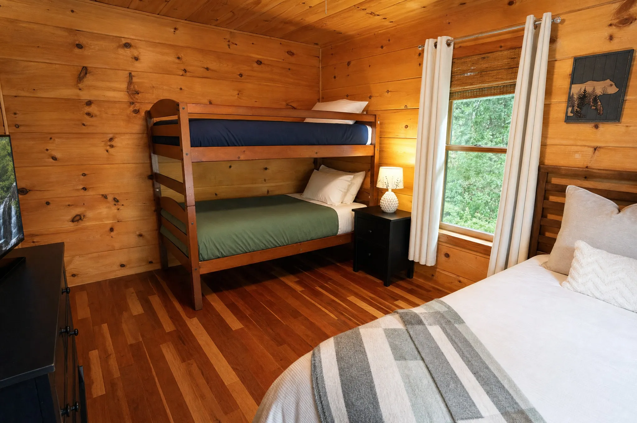 Twin bunk beds beside the queen bed in the main-level bedroom