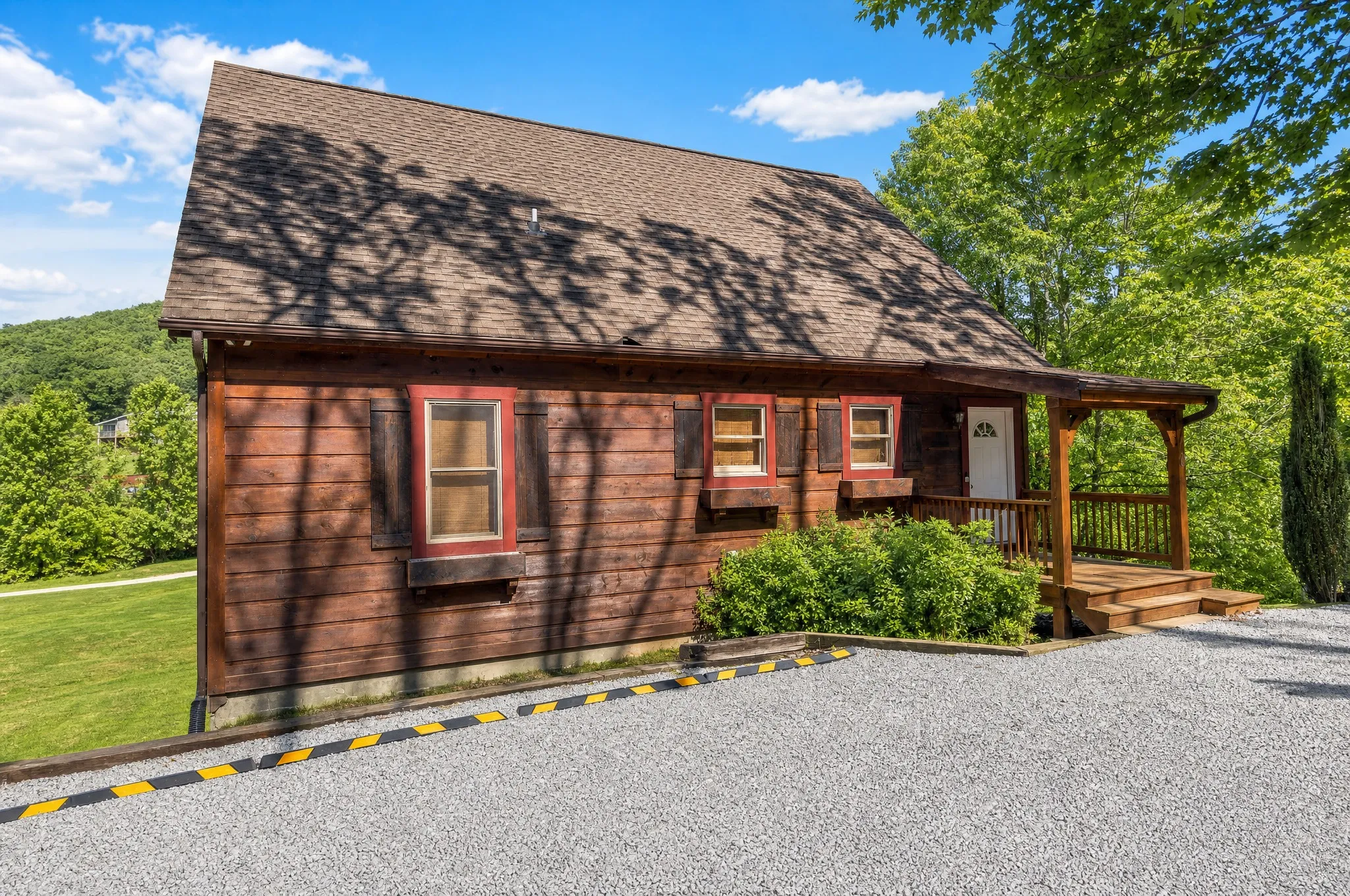 Front of the Vilas NC mountain cabin in summer with gravel parking